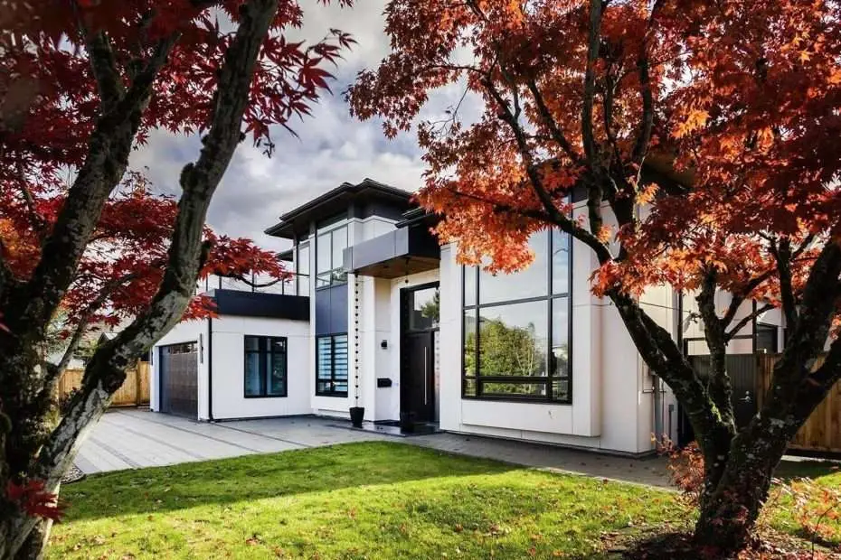 A modern home with a balcony and a terrace, featuring large, energy-efficient SILEX windows and doors from the front-entrance with Trees in sight.