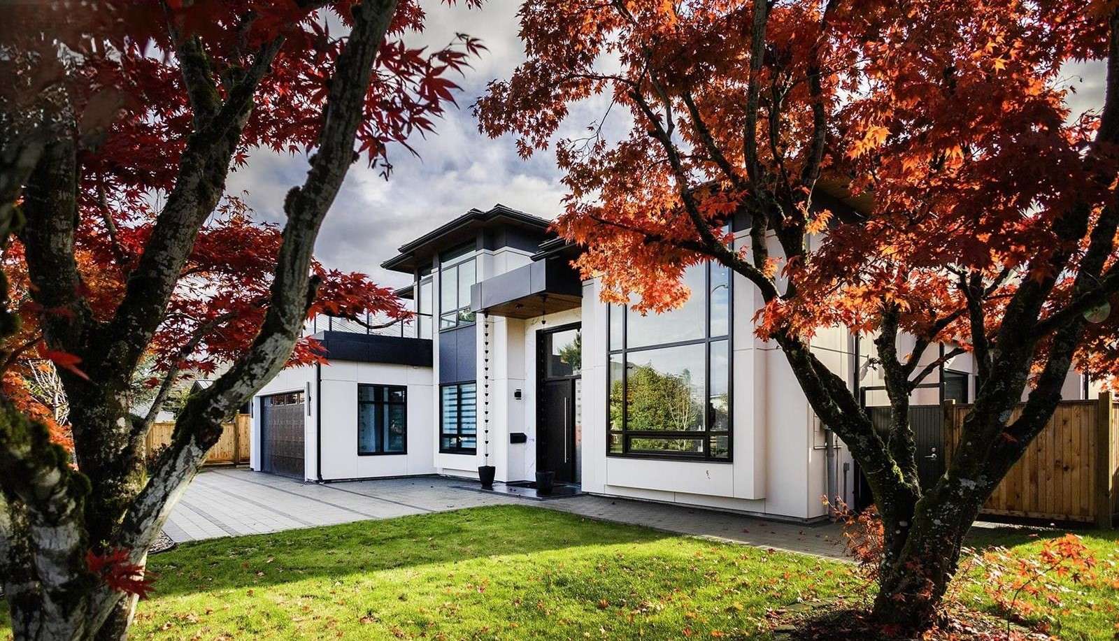A modern home with a balcony and a terrace, featuring large, energy-efficient SILEX windows and doors from the front-entrance with Trees in sight.