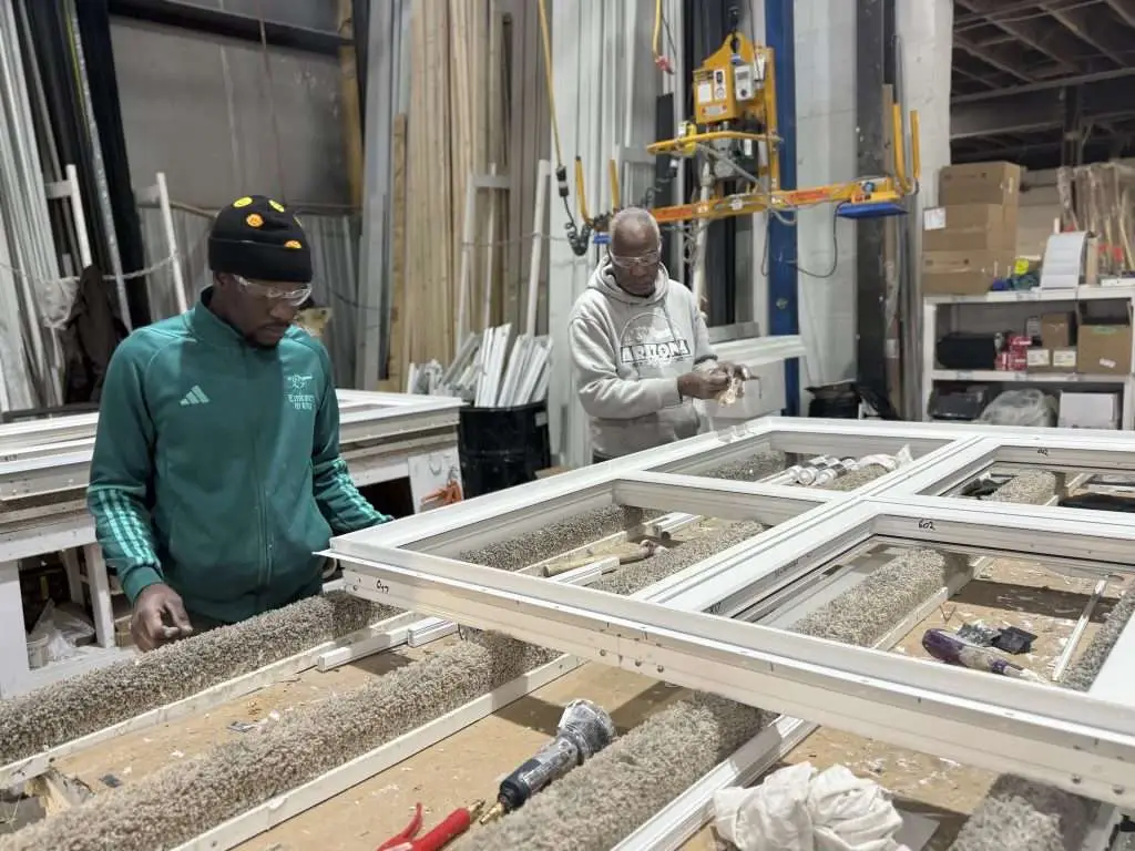 Technical training on fiberglass fenestration systems and thermal sealing during a windows installation program.
